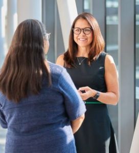 Vicki talking to another person with back to the camera.